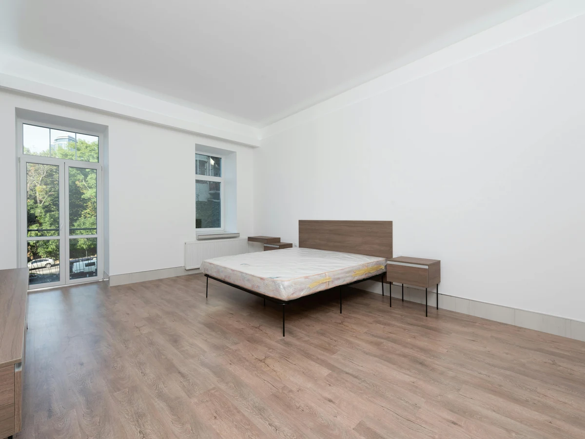 bedroom-painting-minimalist-white-bedroom-cotswolds-decorators A plain white bedroom with a bare bed and wood-effect flooring, ready for the next tenant