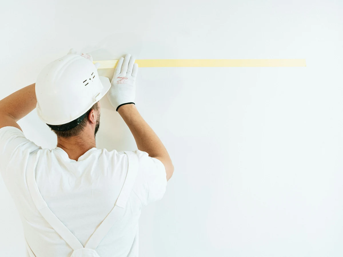 Painter applying masking tape before decorating in Stroud, Cotswolds Decorators