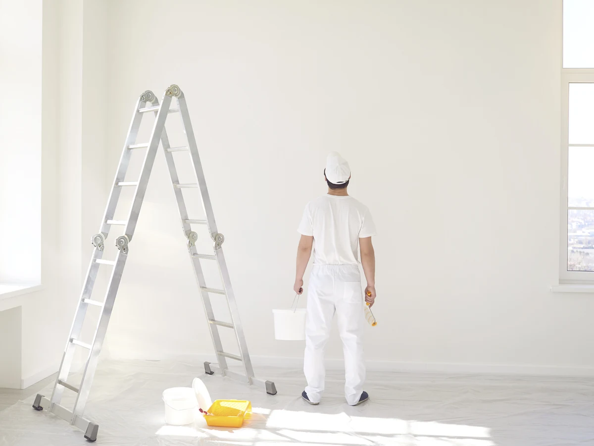 Painter on a white ladder working in Stroud, Cotswolds Decorators